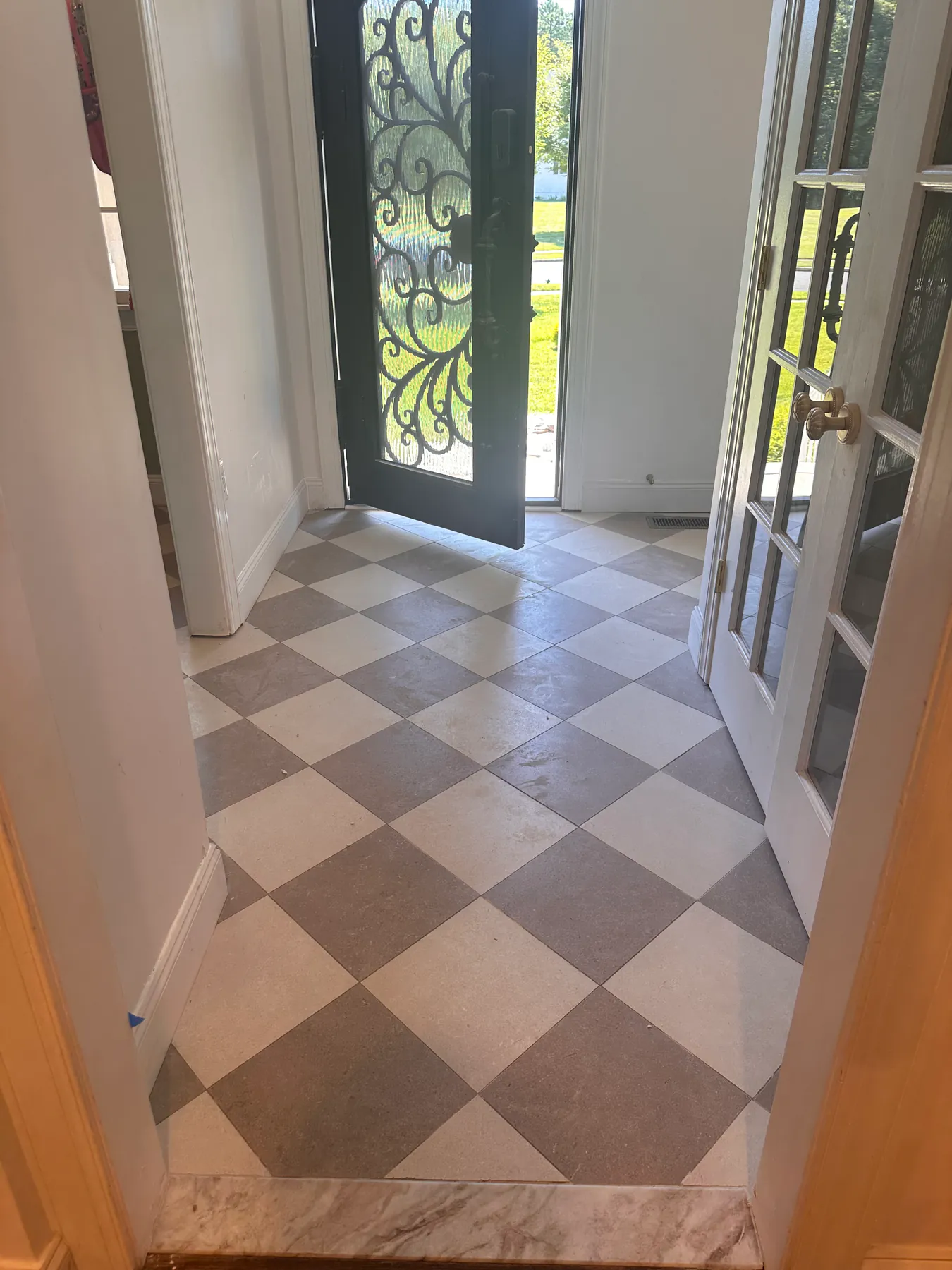 Foyer checkerboard tile floor running from the front door through to the interior french doors
