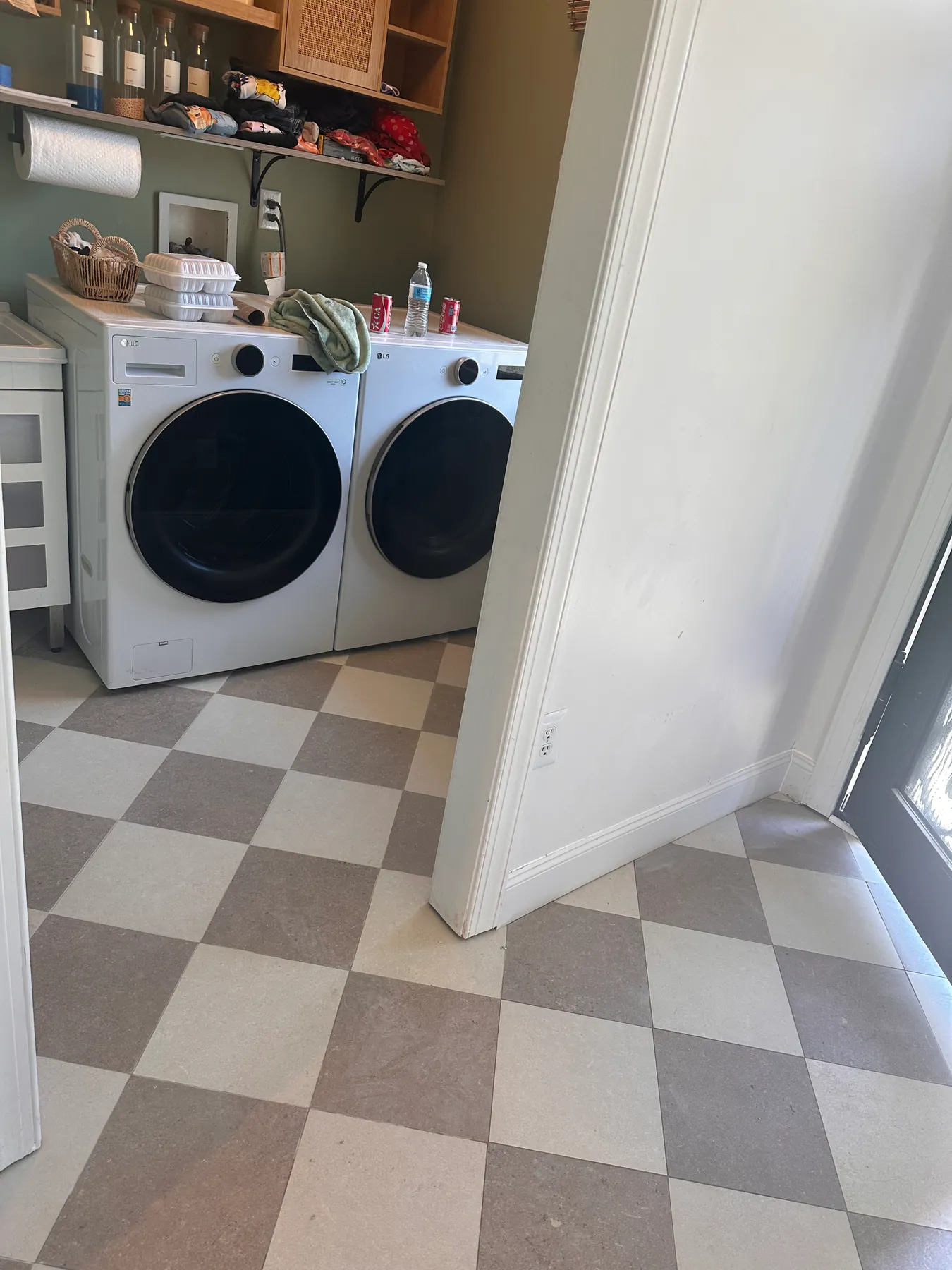 Laundry room with a checkerboard tile floor running under and past the washer and dryer