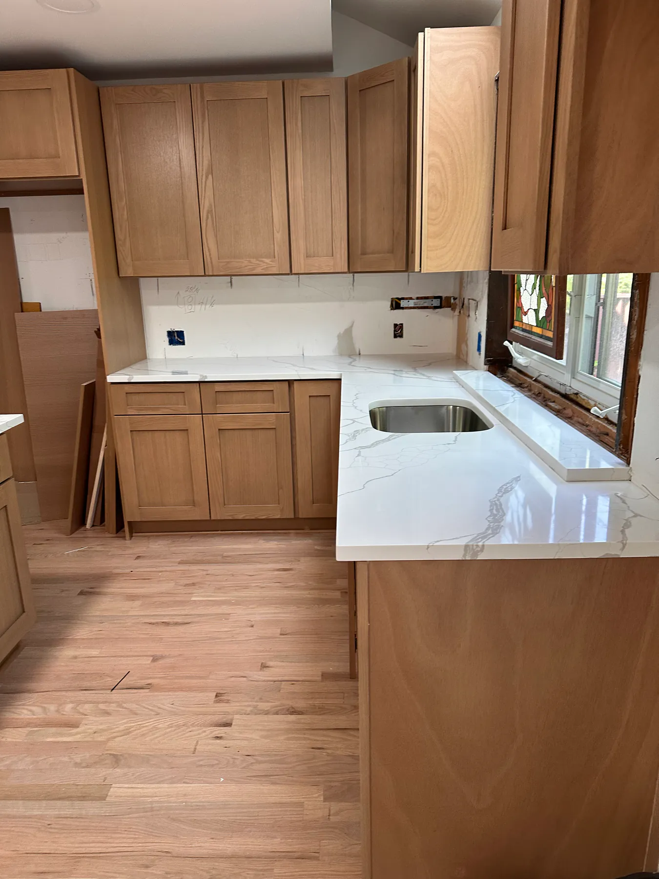 Quartz countertop being set on a kitchen peninsula, veining laid out to run across the seam